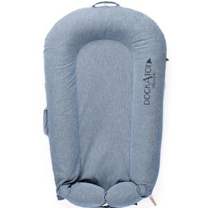 DockATot Deluxe+ baby lounger with indigo chambray denim cover and carry tote